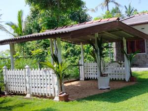 een houten paviljoen met een wit hek en palmbomen bij Beach Corner Weligama in Weligama +20 foto's