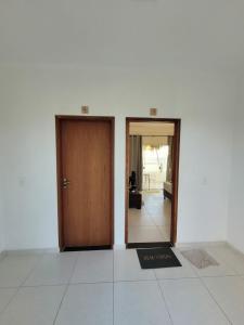 2 Türen in einem weißen Zimmer mit Tür in der Unterkunft Suíte em Japaratinga com Vista do Mar in Japaratinga