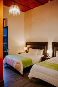 a hotel room with two beds and a chandelier at GRAN ALCÁZAR HOTEL BOUTIQUE in San Luis Potosí