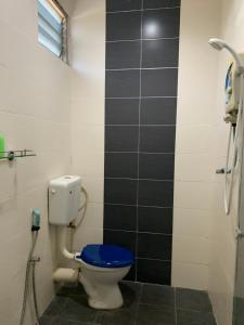 a bathroom with a toilet with a blue seat at Little Chenang Cottage Motel Langkawi in Pantai Cenang