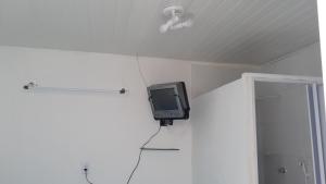 a tv hanging on a wall in a room at Suíte 1 Zona Sul Ilhéus próximo a praia in Ilhéus