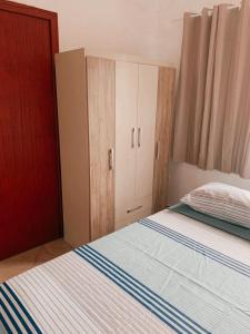 a bedroom with a bed and a cupboard at Pousada Dunas Da Joaquina Novo in Florianópolis