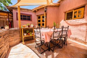 圣佩德罗·德·阿塔卡马Incahuasi Travelodge的房子里有桌子和椅子的露台