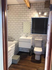 a bathroom with a toilet and a sink and a tub at La Chapelle - The Library in Montagu