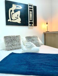 a bed with a blue blanket and pillows on it at Cobertura Duplex: piscina, três quartos e beira á mar in Ilhéus