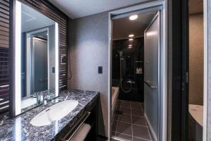 a bathroom with a shower, sink, and mirror at The Park Front Hotel at Universal Studios Japan in Osaka