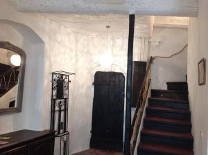 korytarz z czarnymi drzwiami i schodami w domu w obiekcie Maison pittorresque St Paul de Vence w Saint-Paul-de-Vence