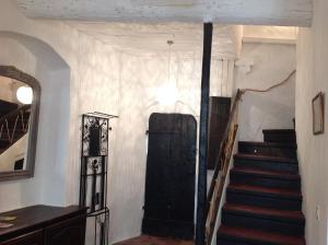 a hallway with a black door and stairs in a house at Maison pittorresque St Paul de Vence in Saint Paul de Vence