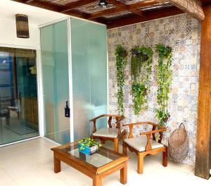 two chairs and a table in front of a wall at Cobertura Duplex: piscina, três quartos e beira á mar in Ilhéus +10 photos