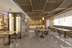 een restaurant met tafels en stoelen en een keuken bij Atour Hotel Baoji Raiway Station Xingzheng Avenue in Baoji
