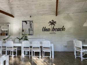 a dining room with a white table and white chairs at Una Beach Hotel & OLU Cafe in Unawatuna