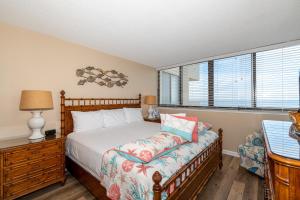 a bedroom with a bed and a lamp and windows at Sands Villas II in Atlantic Beach