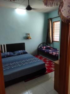 a bedroom with a bed and a mirror in it at Singgahan Keluarga Jitu in Jitra