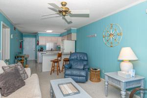 a living room with blue walls and a ceiling fan at Seaspray in Atlantic Beach