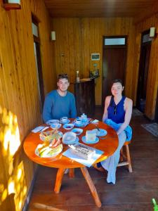 a man and a woman sitting at a table at CHILL WOOD HOMESTAY ELLA in Ella