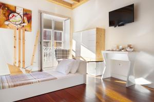 a living room with a white couch and a tv at Stay in the heart of Porto! in Porto