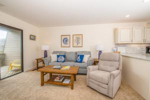een woonkamer met een bank, een stoel en een tafel bij Ocean Grove in Pine Knoll Shores
