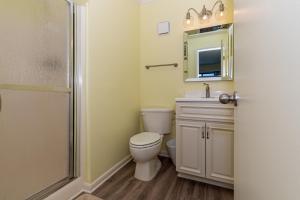 a bathroom with a toilet and a sink and a mirror at Dunescape Villas in Atlantic Beach