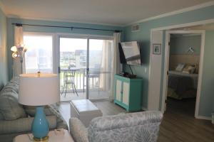 a living room with a couch and a table with a lamp at A Place At The Beach V in Atlantic Beach