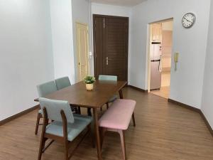a dining room with a table and chairs and a clock at Spacious 3 rooms Apartment@Desa Putra Condominium in Kuala Lumpur