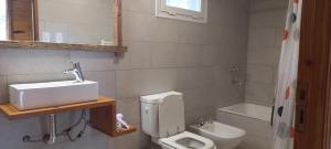 een badkamer met een wastafel, een toilet en een bad bij Cabañas Boutique Los Cipreses in Villa Ventana