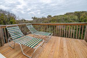 two chairs sitting on the deck of a house at Pine Knoll Townes in Pine Knoll Shores
