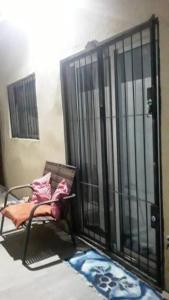 um quarto com um portão com uma cadeira em frente em N1 2 Apto Pequeño Habitación con baño privado a 120 metros de Plaza Batlle punto Central de la Ciudad em Artigas