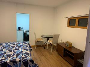 1 dormitorio con 1 cama, mesa y sillas en Viña City Hostel II, en Viña del Mar