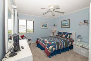 a bedroom with a bed and a desk with a tv at Seaspray II in Atlantic Beach