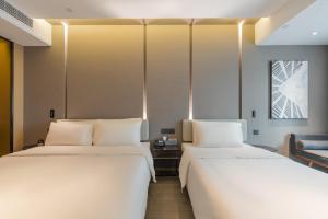 two beds sitting next to each other in a room at Atour Hotel Quzhou Nankong in Quzhou