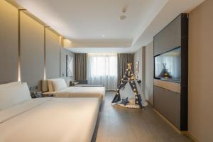 a hotel room with two beds and a television at Atour Hotel Quzhou Nankong in Quzhou