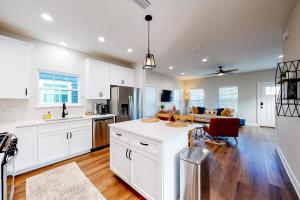 an open kitchen and living room with white cabinets at Downtown Livin' in Pensacola