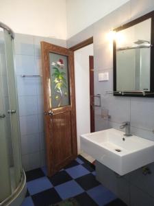 ein Bad mit einem Waschbecken und einem Spiegel in der Unterkunft Villa seaside in Bentota
