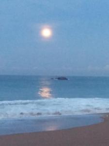 Ein Mond erhebt sich über dem Meer mit einem Strand in der Unterkunft Villa seaside in Bentota