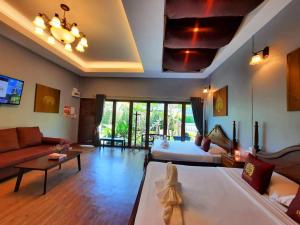 a large living room with a couch and a bed at Amantra homestay & village in Suratthani