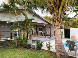 a house with a palm tree next to a pool at La Kzaline in Petite Île