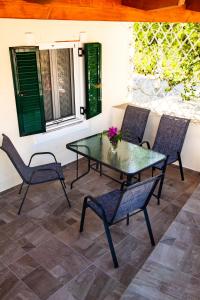 a glass table and chairs on a patio at Spyran Apartment in Marantochori