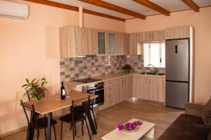 a kitchen and dining room with a table and a refrigerator at Spyran Apartment in Marantochori