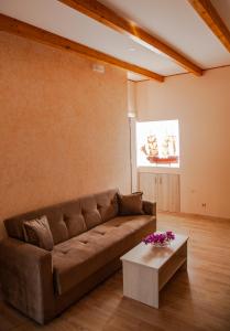 a living room with a brown couch and a table at Spyran Apartment in Marantochori