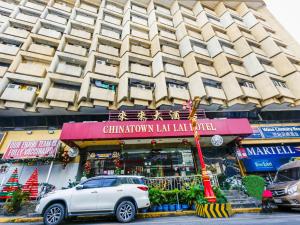 um carro branco estacionado em frente a um edifício em Chinatown Lai Lai Hotel Inc em Manila