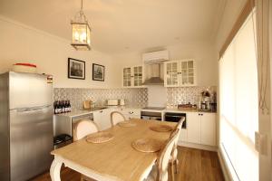 里奇蒙的住宿－Bridgecroft Villa - French Provincial in Richmond with spa，厨房配有木桌和冰箱。