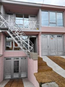 a pink house with a staircase in front of it at Apartaestudio calido y bien ubicado en Manizales in Manizales