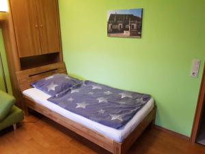 a small bed in a room with a green wall at Ferienwohnung Jestel in Einbeck