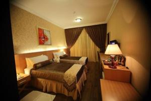 Habitación de hotel con cama y lámpara en Meral Hotel, en La Meca