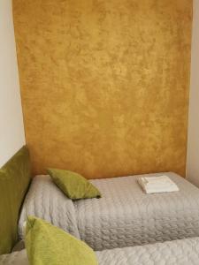 a small bed with green pillows in a room at Ca Cristallina in Venice