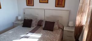 a bedroom with a bed with pillows on it at Ideal location Very spacious apartment in Maspalomas