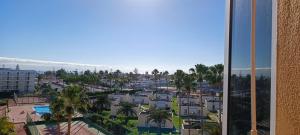 a view of a city from a building with palm trees at Ideal location Very spacious apartment in Maspalomas