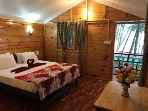 a bedroom with a bed in a room with wooden walls at Cola Beach Exclusive Resort in Cola