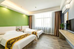 een hotelkamer met 2 bedden en een flatscreen-tv bij Suoxing Hotel Longxian Passenger Bus Station in Long