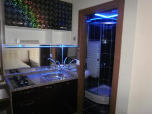 a bathroom with a sink and a toilet with blue lights at Ceylan Apart Otel in Tekirdağ